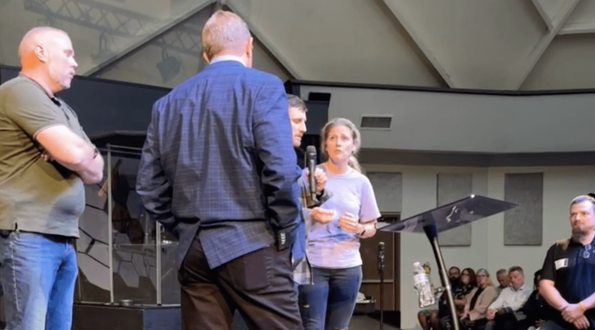 Church embraces pastor who admits to "adultery" despite victim saying she was 16 | The victim (center right) and her husband (center) confront Pastor John B. Lowe