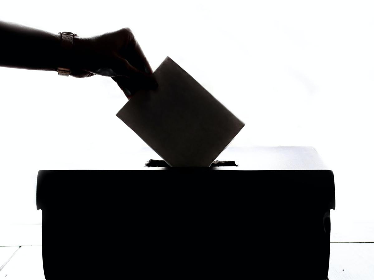 Attempting to combat voter fraud, Republicans willing to build " army". Silhouette hand placing vote in ballot box