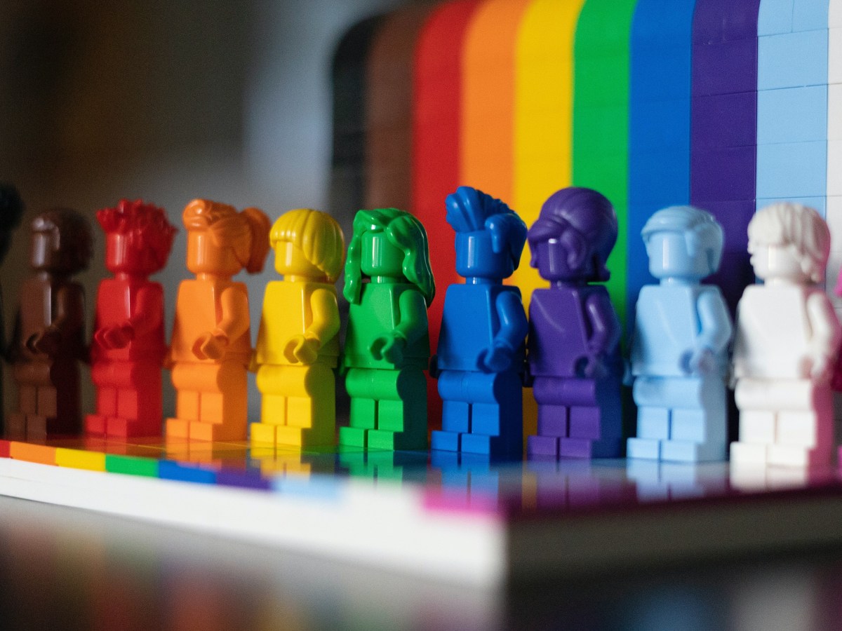 The A in LGBTQIA does not stand for ally | multicolored figurines standing in front of a rainbow