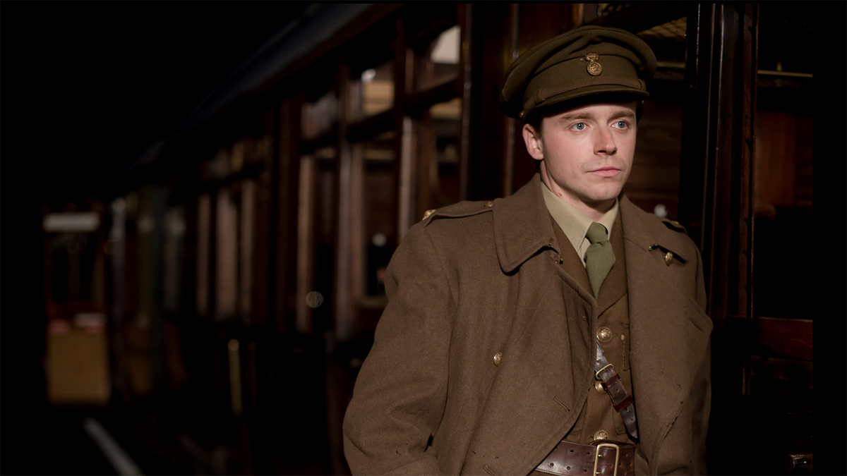 “Benediction” offers no ‘good word’ about war | Jack Lowden, portraying Siegfried Sassoon, in officer's uniform standing by a train