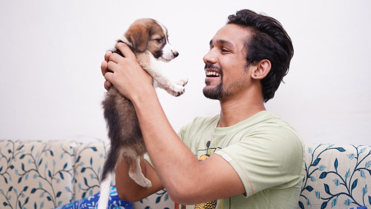 Is Sentience Better in Practice than Humanism? | Man holding up puppy