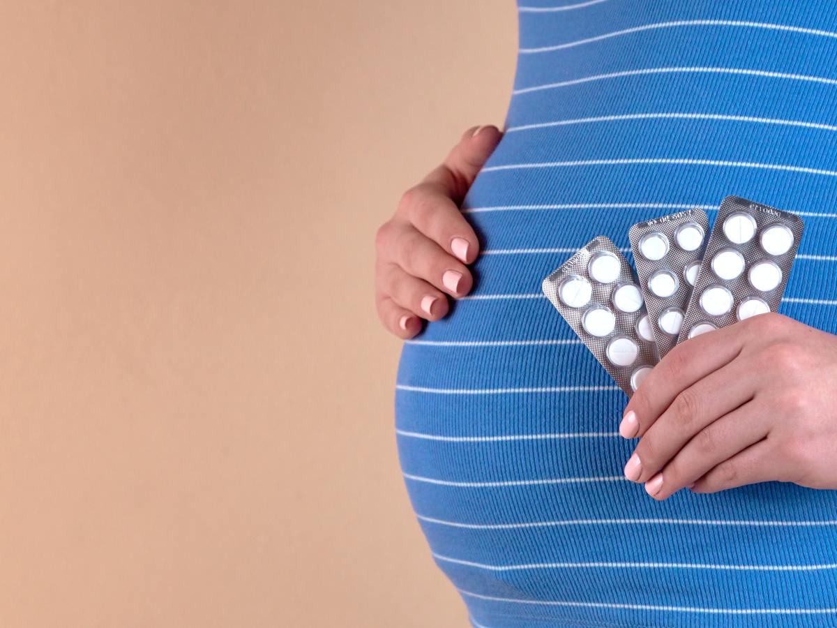 The terrible side effects of a post-Roe world | pregnant woman holding pills